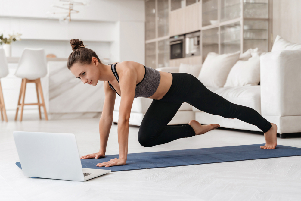 Young,Fit,Girl,Doing,Fitness,Exercise,At,Home,While,Watching